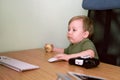 Small child is busily using computer, using mouse Royalty Free Stock Photo