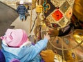 A small child caresses a beautiful and colorful traditional carnival mask by placing his finger tenderly on his face