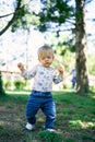 Small child with a carrot in his hand walks on the green grass in the park Royalty Free Stock Photo