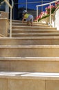 Small child climbs up on steps of beige stairs