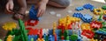 A small child collects a construction kit from colorful parts. hands.