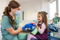 A small child at a dentists appointment, the doctor shows and tells how to brush your teeth