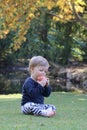 Small child eating an apple fruit outside - baby biting into an apple Royalty Free Stock Photo