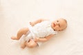 A small child a girl 6 months old is lying on a white bed Royalty Free Stock Photo