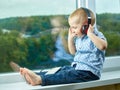 A small child in headphones and with a mobile phone listens to music Royalty Free Stock Photo