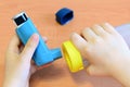 Small child holding asthma inhaler and spacer in his hands. Asthma spacer and aerosol inhaler Royalty Free Stock Photo