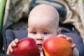 Small child holding both hands two apples