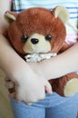 A small child is holding a brown teddy bear toy in his hands. Royalty Free Stock Photo