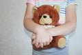 A small child is holding a brown teddy bear toy in his hands. Royalty Free Stock Photo
