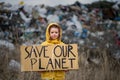 Small child holding placard poster on landfill, environmental pollution concept. Royalty Free Stock Photo