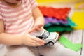 Small child is holding toy car. kid plays with car on floor. Travel concept. Royalty Free Stock Photo