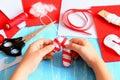 Small child holds Christmas felt candy cane in his hands. Sewing supplies to make Christmas tree decorations Royalty Free Stock Photo