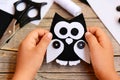 Small child holds a felt owl toy in his hands. Child shows a cute felt owl toy. Teaching kids simple sewing skills at home