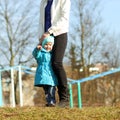 Small child holds on mom feet. Smiling baby. Royalty Free Stock Photo