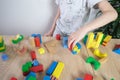 Small child, kid plays with colored wooden cubes, builds houses and rockets, the concept of the development of creativity, fine