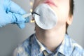 Small child, kid 7-8 years old raised his head, assistant treats a wound on the chin, part of the face close-up, examination by a