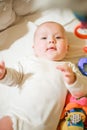 A small child lies in a crib near educational toys Royalty Free Stock Photo