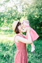 A small child, a little girl sitting in lap of her mother, looking into each other`s eyes, hugs her, warm and Sunny day