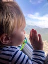 A small child looks into the window of an airplane. Tourism concept