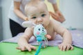 A small child lying on his stomach gets a massage in a massage room. He has a toy in his mouth Royalty Free Stock Photo