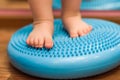 Little kid massages his feet while standing on the rug Royalty Free Stock Photo