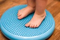 Little kid massages his feet while standing on the rug Royalty Free Stock Photo