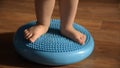 Little kid massages his feet while standing on the rug