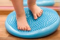 Little kid massages his feet while standing on the rug Royalty Free Stock Photo