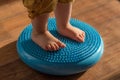 Little kid massages his feet while standing on the rug Royalty Free Stock Photo