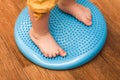 Little kid massages his feet while standing on the rug Royalty Free Stock Photo