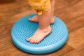 Little kid massages his feet while standing on the rug Royalty Free Stock Photo