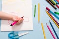 a small child painstakingly draws with a pink felt-tip pen in an album Royalty Free Stock Photo