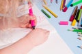 a small child painstakingly draws with a pink felt-tip pen in an album Royalty Free Stock Photo