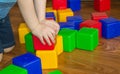 A small child playing with colorful cubes builds a tower, the concept of early education preparation for the development of the Royalty Free Stock Photo