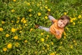 Small child playing on a green meadow surrounded with yellow flowers Royalty Free Stock Photo