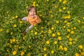 Small child playing on a green meadow surrounded with yellow flowers Royalty Free Stock Photo