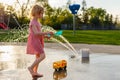 Small child playing at splash pad playground in summer. Water park with fountains for children Royalty Free Stock Photo