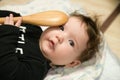 A small child is playing with a spoon. old kitchen toys. close up of babies hands playing with wooden spoon and pot baby chef Royalty Free Stock Photo