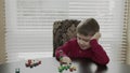Small child, preschooler playing with wooden blocks. Caucasian boy in a red sweater building with blocks.