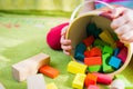 Small child playing with wooden blocks on green carpet Royalty Free Stock Photo