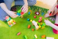 Small child playing with wooden blocks on green carpet Royalty Free Stock Photo