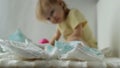A small child plays with baby diapers, background, hygienics