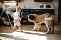 little child plays in the house with a St. Bernard puppy.