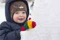 Small child plays on the street in the winter with a large ice floe