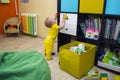 A small child plays with toys in the children`s room pasted