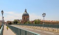 Small child riding a bicycle safely in bike lane on a scenic European bridge