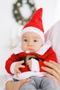 Child in a Santa suit looks sad. Christmas and New year