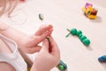 a small child sculpts from plasticine on a wooden table, the development of fine motor skills of hands
