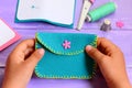 Small child sewed a purse of felt. Small child holds a purse in his hands. Simple handmade crafts for kids concept