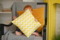 Small child sits in a chair and holds a pillow in his hands.